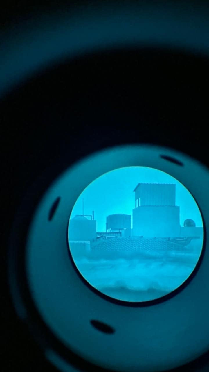 Close-up of the 55mm objective lens on the L3Harris AN/PVS-24 M2124 clip-on night vision device showing optical clarity and build quality

